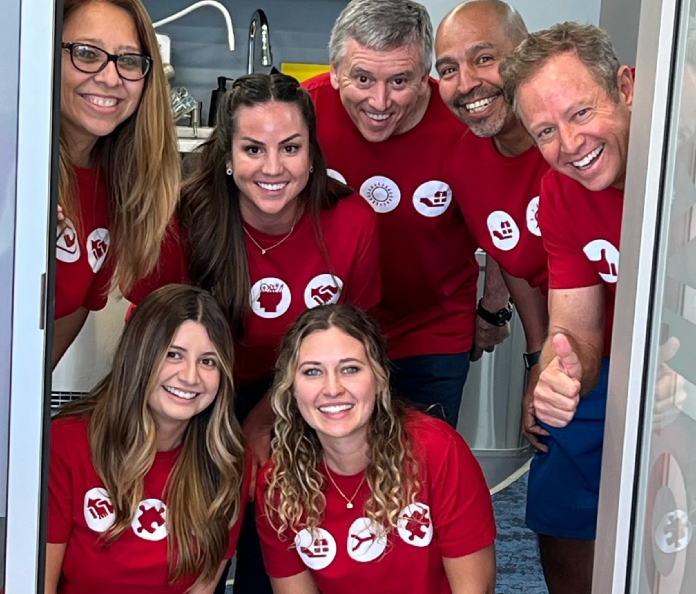 Collaborative WHY Institute team smiling around a laptop